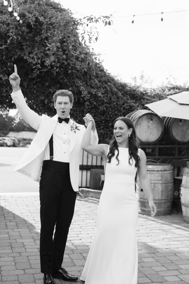 Bride and groom celebrating outdoors, black-and-white.