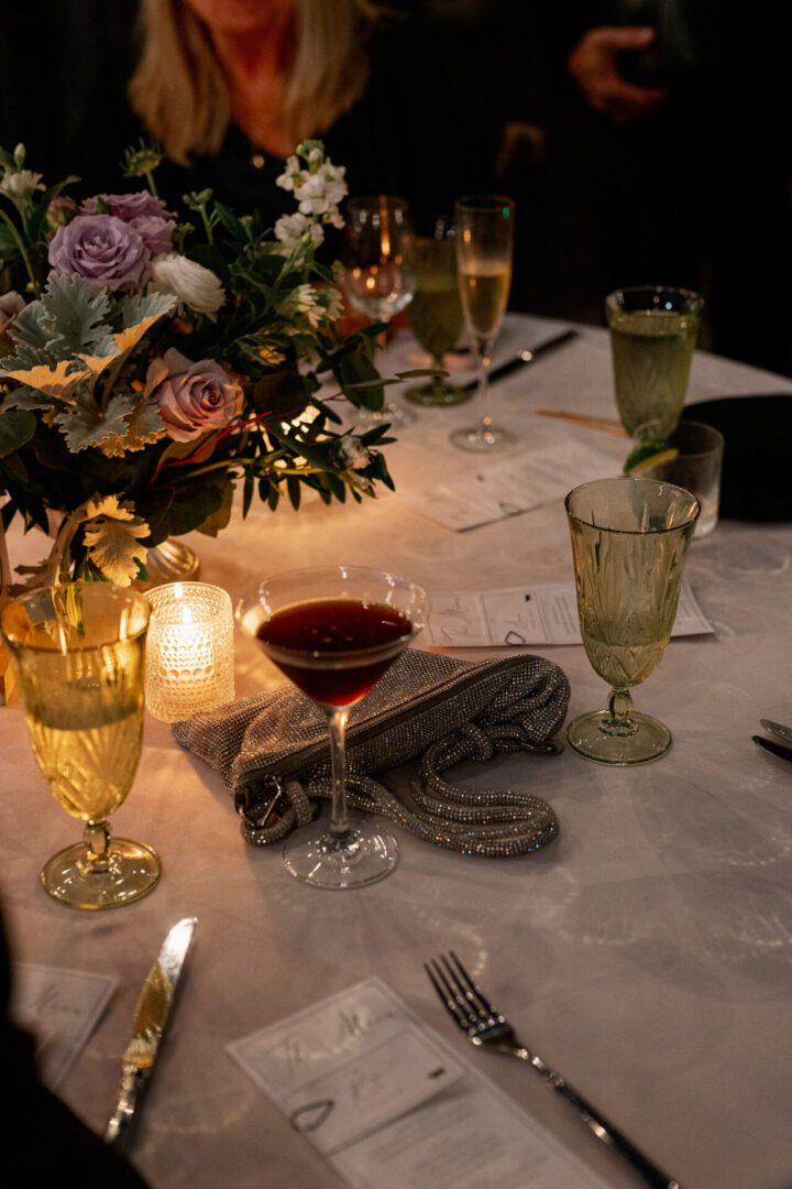 Elegant dinner table with flowers and drinks.